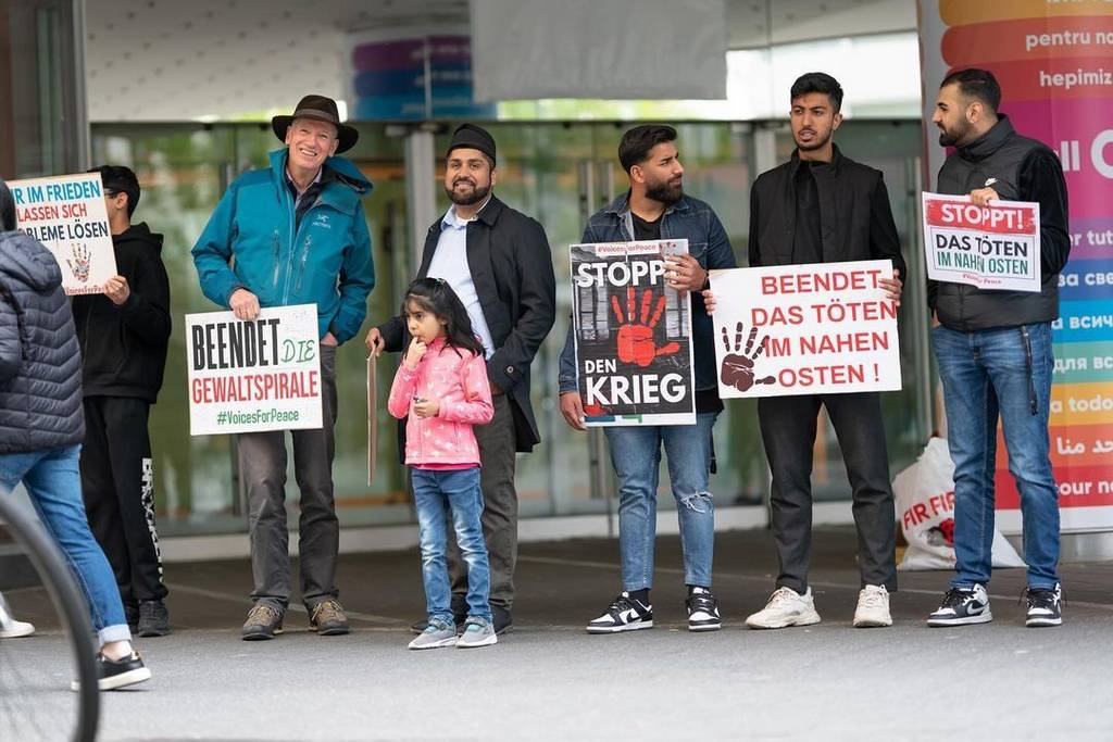 Menschen zeigen Plakate mit Friedensbotschaften