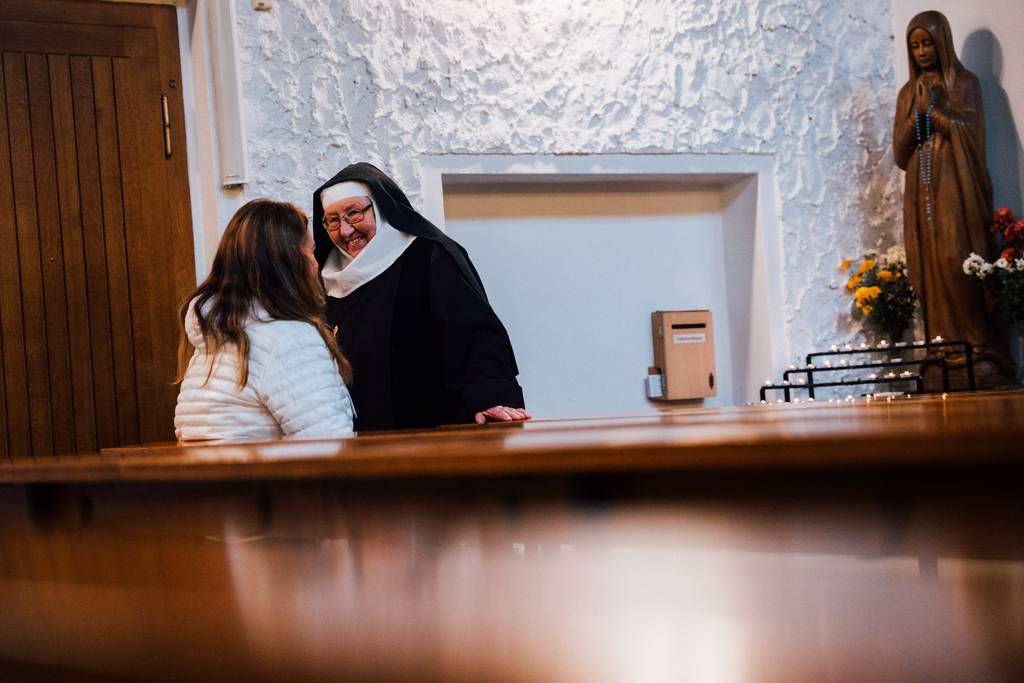 Eine Nonne im Gespräch mit einer Kirchenbesucherin